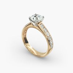 a yellow gold engagement ring with channeled diamonds on the sides and a side band