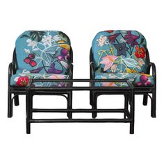 two chairs sitting next to each other in front of a white background with flowers on them