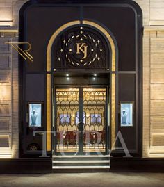 an entrance to a building with glass doors and gold trimmings on the front