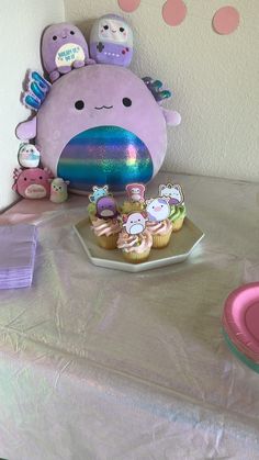 a table topped with cupcakes and stuffed animals