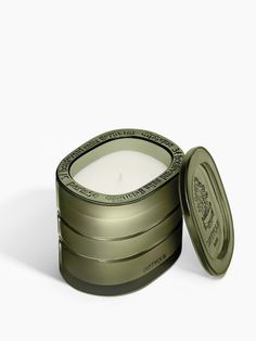 a candle in a tin with the lid open