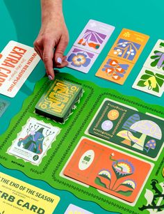 a person is placing cards on top of a table that has different designs and colors