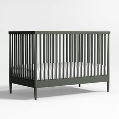 a baby crib with white sheets on it