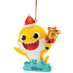 a yellow and white ornament with a shark holding a bell