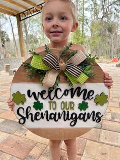 a young boy holding up a welcome sign for st patrick's day at the park