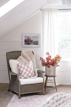 a room with a chair, potted plant and pictures on the wall