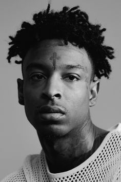 a black and white photo of a young man with dreadlocks on his head