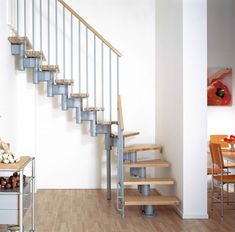 there is a set of stairs in the room with wood flooring and white walls