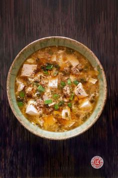 A bowl of hot and sour soup with tofu and ground meat.