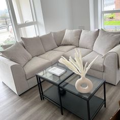 a living room with a couch, coffee table and large window in the back ground