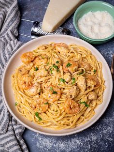 a plate of pasta with shrimp and parmesan cheese