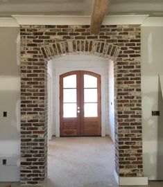 an empty room with a door and brick wall in the middle, surrounded by unfinished plaster