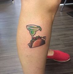 a tattoo on the leg of a person with a taco and a drink in it