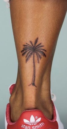 a woman's foot with a small palm tree tattoo on the side of her ankle