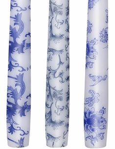 three blue and white candles with designs on them