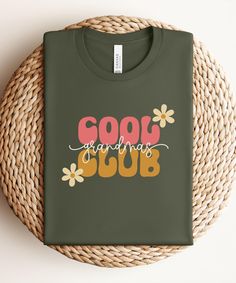 a green t - shirt with the words good morning club on it sitting next to a wicker basket