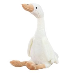 a stuffed duck sitting on the ground with its legs spread out and head turned to the side