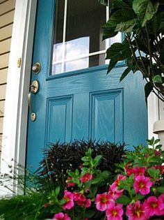 the front door is painted blue and has pink flowers