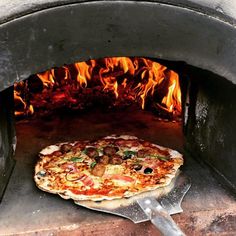 a pizza is cooking in an outdoor oven