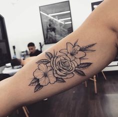 a black and white rose tattoo on the arm