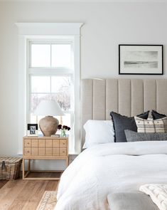 a bedroom with white walls and wooden floors