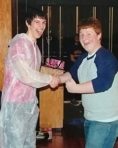 two young men shaking hands in front of a podium