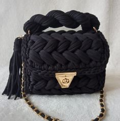 a black purse with a gold chain on it