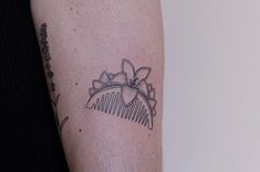 a tattoo on the arm of a woman with flowers and a comb in her hair