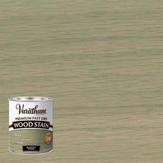 a can of wood stain sitting on top of a wooden floor next to a wall