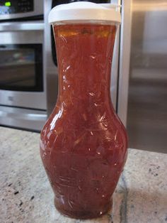 a red vase sitting on top of a counter next to an oven