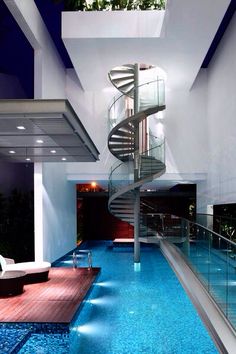 an indoor swimming pool with a spiral staircase in the center and blue water running through it