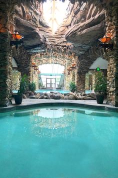 an indoor swimming pool surrounded by stone walls