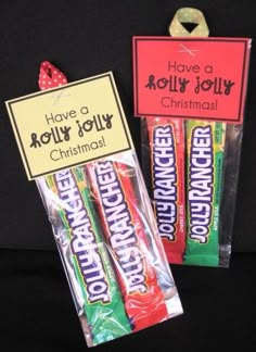 two candy bars are sitting next to each other on a black surface with a sign that says have a holly jolly christmas