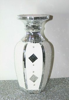 a silver and white vase sitting on top of a glittery tablecloth covered floor