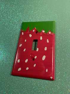 a red and green light switch cover with white polka dots on the inside of it