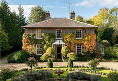 a large brick house surrounded by trees and bushes