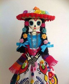 a mexican doll is wearing a colorful dress and sombrero with flowers on her head