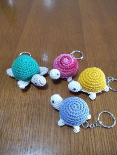 three crocheted turtle keychains sitting on a wooden table next to each other