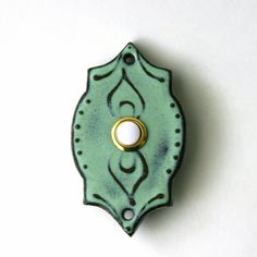 a green wall mounted light switch cover with a gold ring on it's center