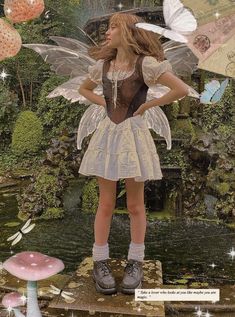 a woman dressed as a fairy standing in front of a pond with mushrooms and butterflies