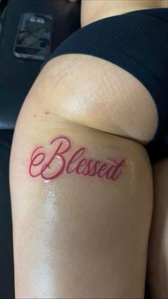 a woman with a tattoo on her thigh that says,'be loved'in red ink