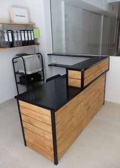 an office desk with drawers and a printer on it in front of a glass wall