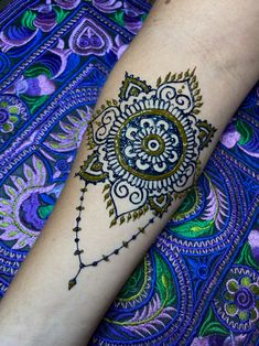 a woman's arm with a henna tattoo design on the side of it