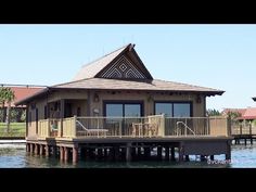 a house sitting on top of a pier next to the ocean