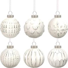 four white christmas ornaments hanging from strings on a white background, each decorated with an ornament