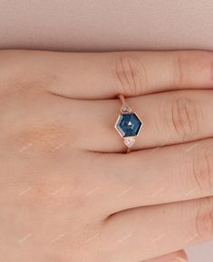 a woman's hand with a diamond and blue sapphire ring on her left hand