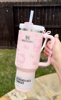 a person holding a pink hello kitty coffee cup