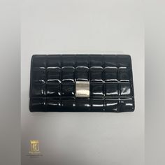 Chanel Chocolate Bar Long Wallet Black Patent Leather With Silver Tone Hardware Approximately 7.5x0.5x4” Date Code: 7725645 Interior Has- 3 Long Slots (Including Slot Under Flap), 2 Card Slots And 1 Zip Pocket Zip Pocket Is Missing Its Original Zipper Pull Item Shows Signs Of Wear From Use- Scratches And Scuffs On Leather, Tarnished And Scratched Hardware, Missing Interior Zipper Pull, Small Crack In Leather Under Flap, Small Stains, Etc Please Refer To Photos For Further Details Jask84208z3 Chanel Black, Chocolate Bar, Long Wallet, Black Patent Leather, Chanel Bag, Card Slots, Patent Leather, Black Silver, Slots