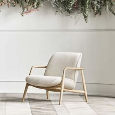 a chair sitting in front of a wall with flowers hanging from it's sides