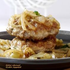 two meat patties covered in gravy on top of pasta